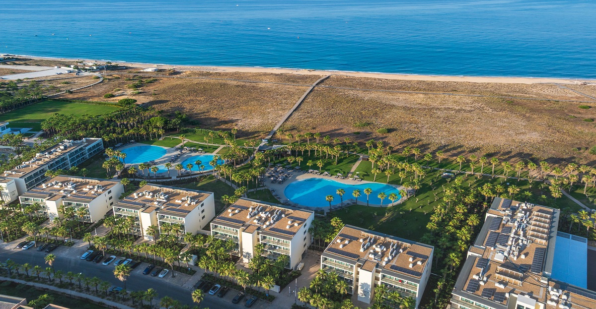 Aerial view of a luxury beach resort and golf course in the Algarve, represented by LUXIMOS Christie's.