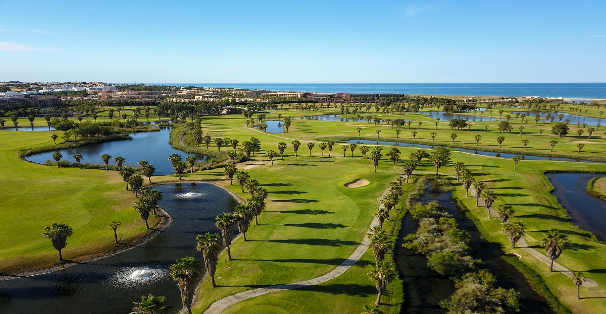 Campo de golfe dos Salgados, no Algarve, com fairways junto à lagoa, zonas naturais e próximo do mar.